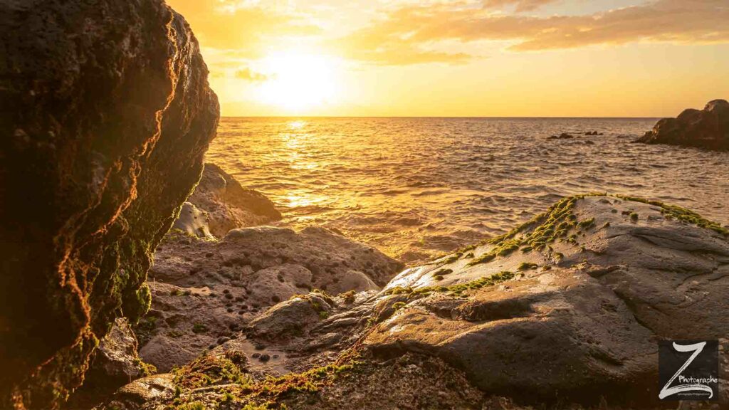photo de paysage de l'île de la Réunion prise par rdijoux montant un coucher de soleil sur la mer, avec en premier plan des rochers