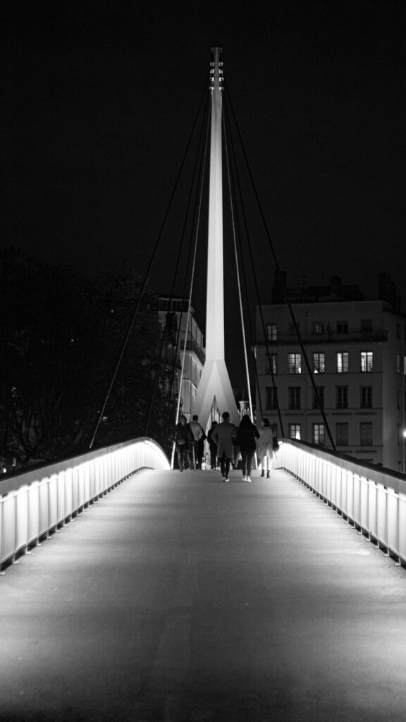 photo d'architecture qui montre un batiment un pont illuminer en noir et blanc