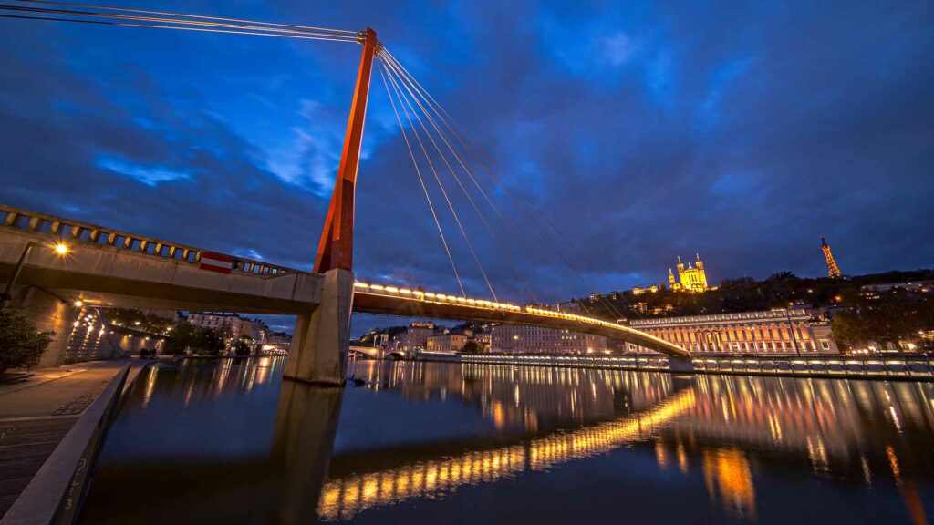 photo d'architecture qui montre un pont lumineux de nuit a Lyon